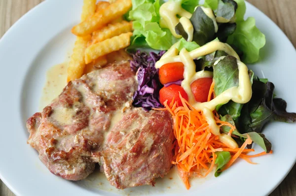 Vepřový steak s mix zeleniny a francouzské opékané brambory — Stock fotografie