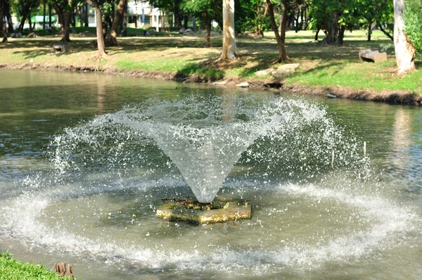 Small fountain floating on lake — Stock Photo, Image