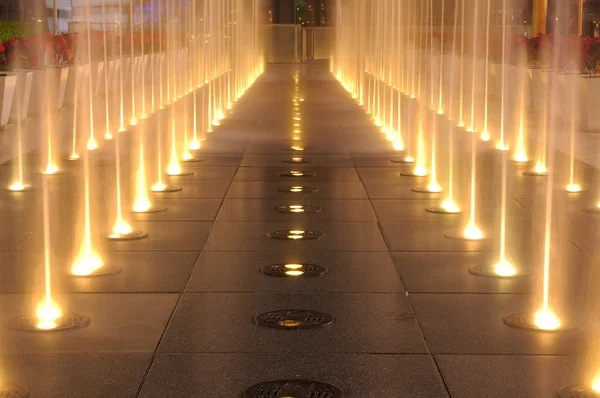 Multiple jets of water in a fountain, lighting show on ground — Stock Photo, Image