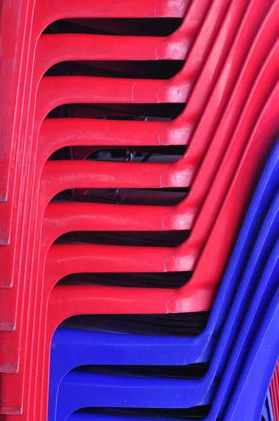 Шаблон из красного и синего пластиковых стульев — стоковое фото