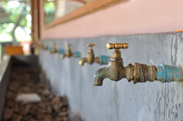 Muchos latones grifo de agua en el fregadero —  Fotos de Stock