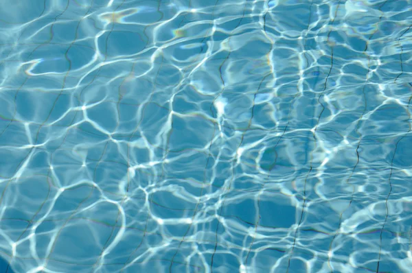 Água rasgada azul na piscina com reflexos ensolarados . — Fotografia de Stock