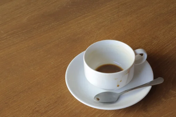 Copo de café branco com colher na mesa de madeira — Fotografia de Stock