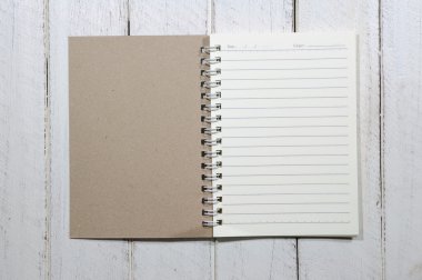 ahşap masa üstünde küçük kağıt defter