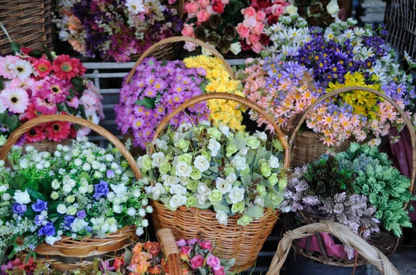 Vele kleurrijke bloemen in rotan mandje tonen등나무 바구니에서 보여주는 많은 다채로운 꽃 — Stockfoto