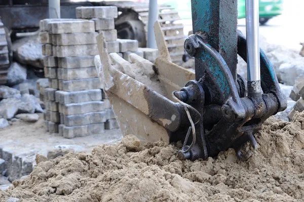 Del av grävmaskin med tegel på arbetsplatsen — Stockfoto