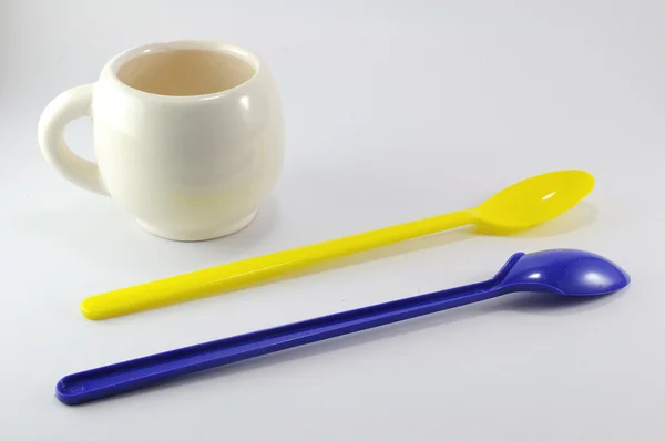 Plastic spoon with small mug — Stock Photo, Image