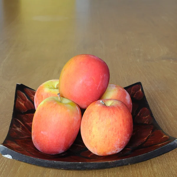 Pommes sur assiette en bois — Photo