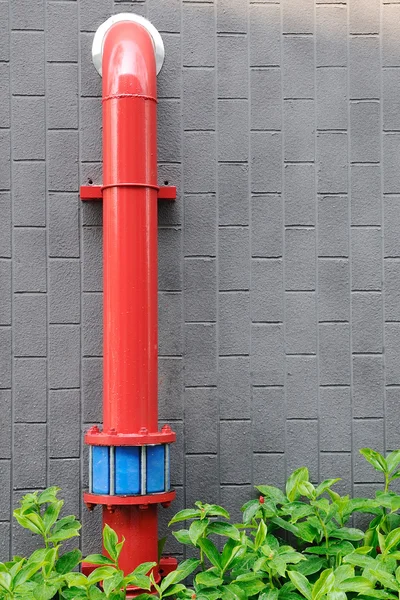 Tubería de agua roja frente a las paredes grises — Foto de Stock