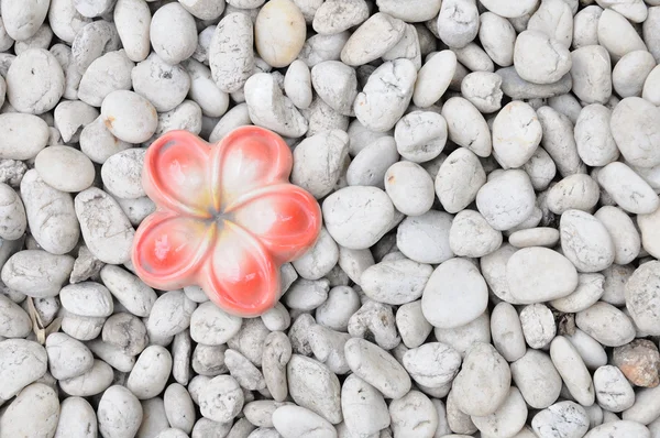 Ceramic flower on white rock — Stock Photo, Image
