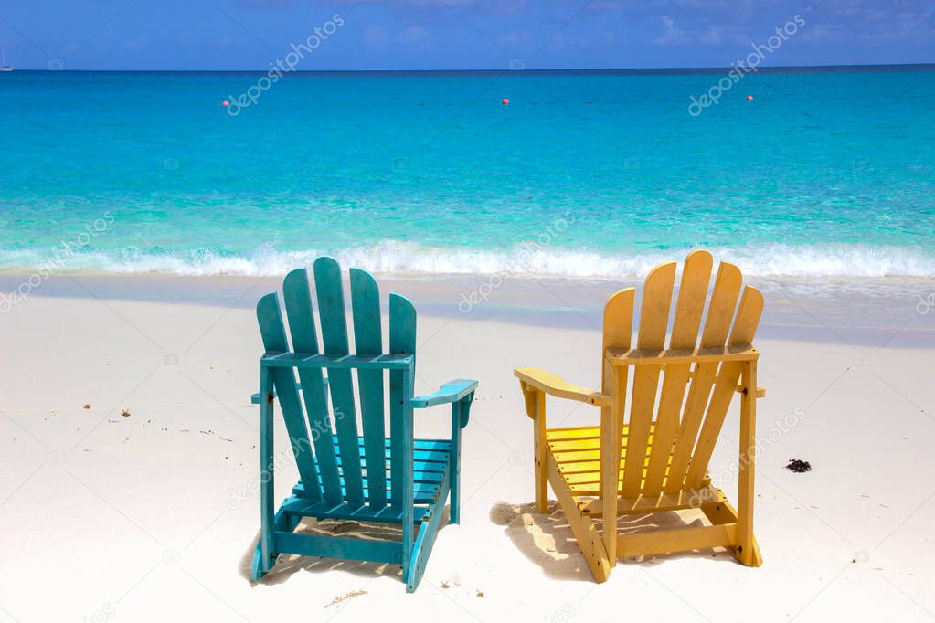 Colorful beach chairs on white sand beach 