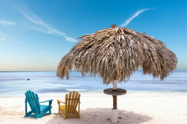 Çatı şemsiyesi ve renkli sandalyeler tropikal kumsalda