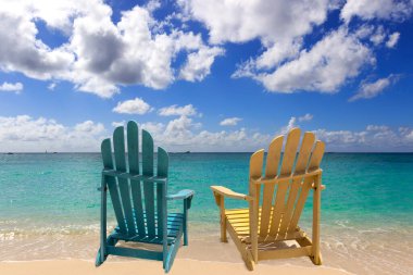 Grand Cayman sahilinde iki renkli kayın sandalyesi