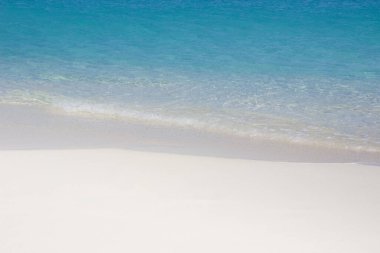 Soft wave of ocean water on white sand
