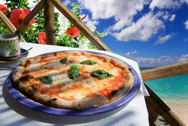 Pizza Margarita served on flower terrace with a sea view, Italy