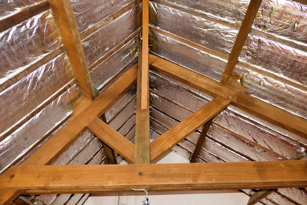 Aluminium foil roof insulation exposed in a vaulted ceiling after wood panelling removed