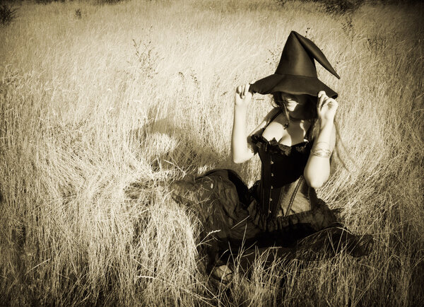 Pretty funny witch sitting in the field