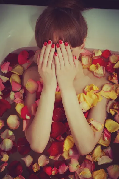 Sadness in the bath full of rose petals — Stock Photo, Image