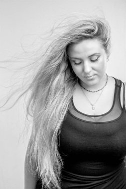 Gri arka planda poz veren güzel bir kadın.