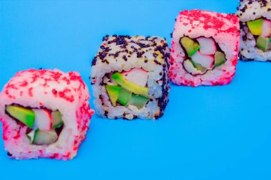 Mavi arka planda bir dizi taze lezzetli rulo