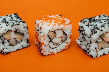 Turuncu arka planda bir dizi taze lezzetli rulo.