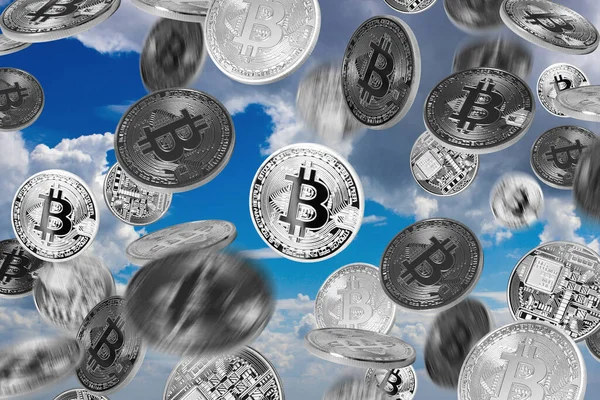 Mavi gökyüzü arkaplanı üzerine düşen bitcoin 'ler