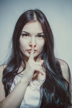 Gri arka planda poz veren tatlı esmer Asyalı kız.