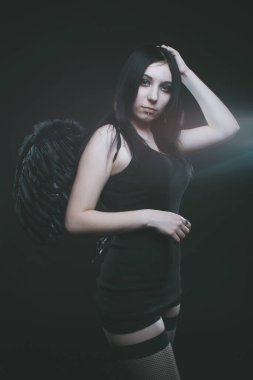 Koyu arkaplanda kanatları olan güzel gotik kız.