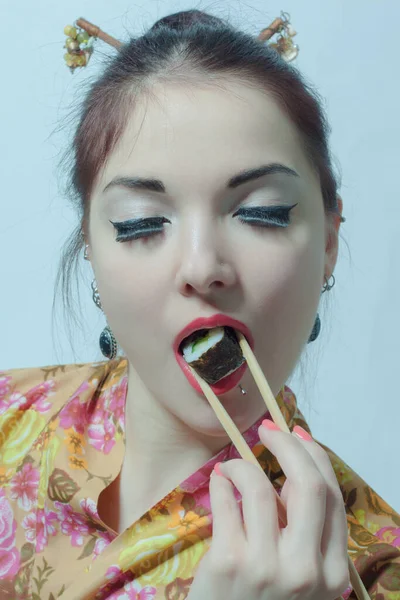 Joven Hermosa Mujer Asiática Comiendo Sushi Sobre Fondo Blanco Imagen de archivo
