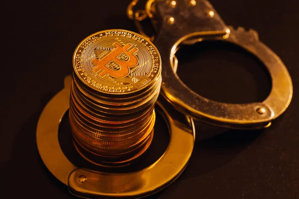 Bitcoins Und Handschellen Vor Schwarzem Hintergrund Stockbild