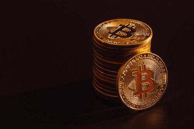 Koyu arkaplan üzerinde bitcoin yığını