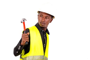 Yeşil yelek giyen, kasklı ve elinde tornavida tutan genç bir erkek teknisyen..