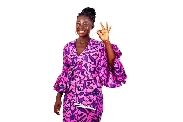 Güzel genç bir iş kadınının portresi geleneksel peştemalli giyinmiş ve parmaklarıyla doğru bir hareket yaparken gülümsüyor..