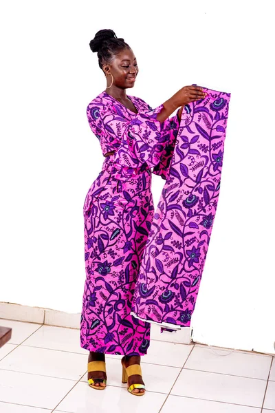 Güzel bir Afrikalı iş kadınının portresi. Elinde geleneksel peştemalle gülümsüyor..