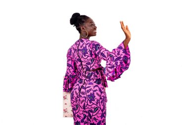 Güzel genç bir iş kadınının portresi. Alışveriş torbalarıyla arkada duruyor ve gülümserken el sallıyor..