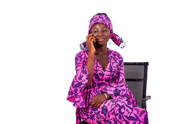 Geleneksel peştemalli güzel bir kadının portresi bir sandalyeye oturmuş ve cep telefonuyla konuşuyor..