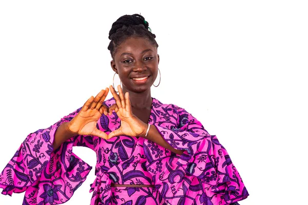 Geleneksel giysiler içinde güzel bir Afrikalı kadın beyaz arka planda durup gülümserken sevgisini gösteriyor..
