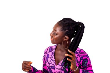 Güzel genç bir kadın geleneksel peştemalli giyiniyor ve saçlarını tutarken gülümsüyor..