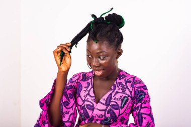 Güzel genç bir kadın geleneksel peştemalli giyiniyor ve saçlarını tutarken gülümsüyor..