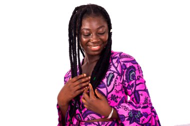 Genç, güzel Afrikalı bir kadın beyaz arka planda dikiliyor siyah saçlarına hayran..