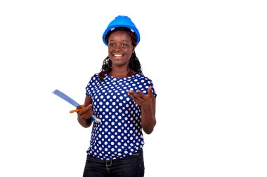 Genç bayan inşaat mühendisi mavi şapka takıyor ve elinde bir pano tutarken gülümsüyor..