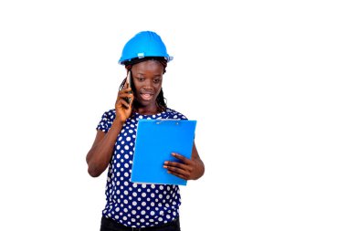 Genç bayan inşaat mühendisi panoda notlar okuyor ve cep telefonuyla konuşuyor..