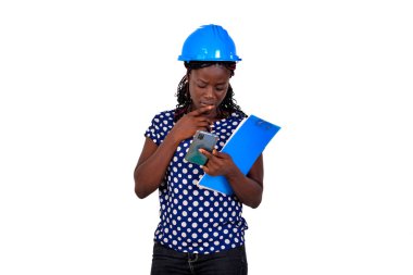Güzel genç bayan inşaat mühendisi elinde bir dosya ve cep telefonu kullanıyor..
