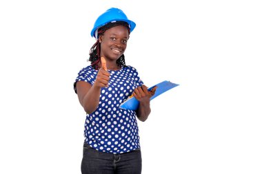 Güzel, genç, mutlu kadın inşaat mühendisi elinde bir pano ve gülümseyerek baş parmağını gösteriyor..