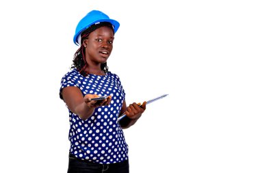 Güzel genç bayan inşaat mühendisi elinde bir pano ve gülümserken bir cep telefonu veriyor..