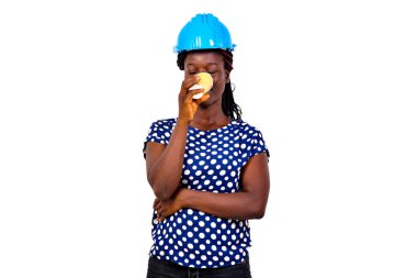 Mavi kasketli güzel bir kadın inşaat mühendisinin portresi kağıt bardaktan kahve içiyor..