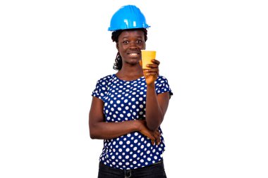 Güzel, genç bir inşaat mühendisinin portresi. Mavi bir şapka takıyor. Elinde bir fincan kahveyle gülümsüyor..