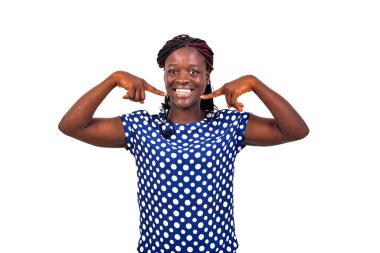 Güzel bir genç kadının portresi beyaz arka planda duruyor ve beyaz dişlerini gösteriyor..