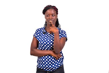 Güzel bir kadının portresi. Beyaz arka plan karşısında duran ve parmaklarını dudaklarında tutarak düşünen genç bir kadın..