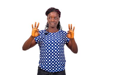 Güzel bir genç kadının portresi beyaz arka planda duruyor ve iki eliyle işaret veriyor..